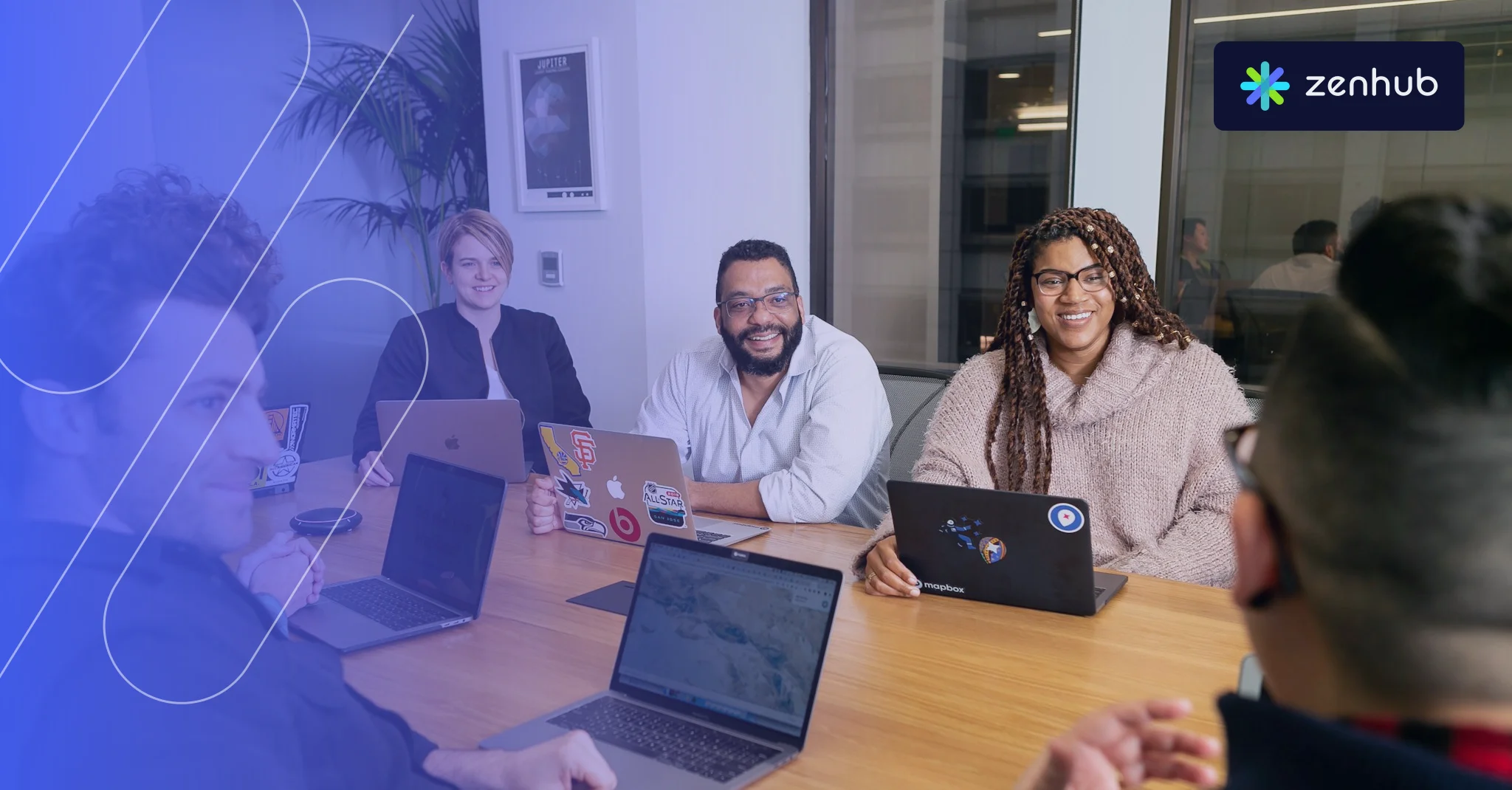 A team meeting around a table with laptops, with a blue Zenhub gradient