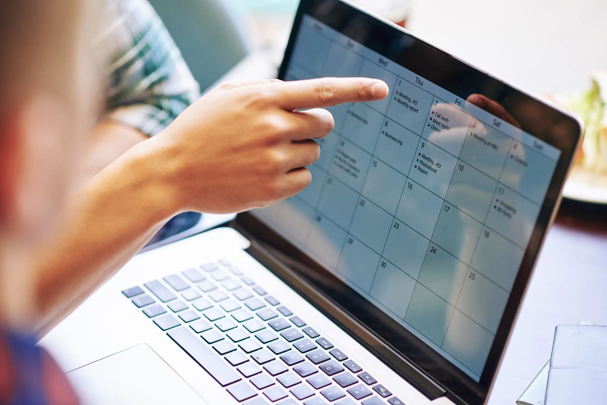Someone pointinng at a full calendar